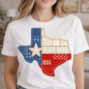 Puede incluir: Camiseta blanca con un diseño de patchwork del contorno del estado de Texas. El diseño incorpora cuadros azules, lunares rojos y una estrella blanca, creando una estética patriótica y artesanal. Es una prenda de vestir informal.