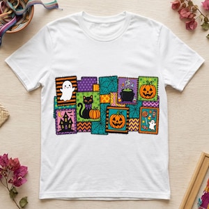 Puede incluir: Una camiseta blanca de manga corta con un gráfico rectangular central compuesto por varios parches con temática de Halloween. El diseño incluye un fantasma, un gato negro, calabazas, un caldero, una casa encantada y dulces.