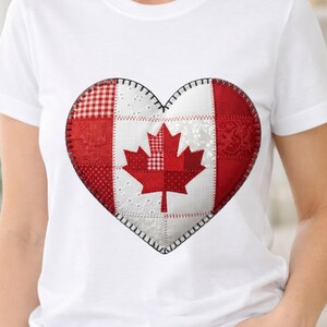 Puede incluir: Una camiseta blanca de manga corta con un gran gráfico en forma de corazón en el pecho. El diseño del corazón imita la bandera canadiense usando un estilo de patchwork con varias texturas de tela roja y blanca y una hoja de arce roja.