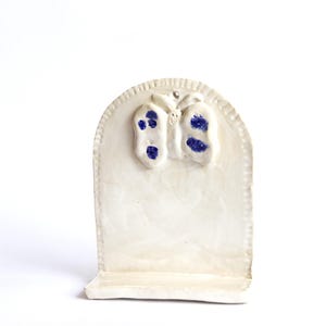 May include: White ceramic dish with a raised butterfly design. The butterfly has blue accents.
