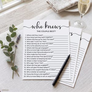 Peut inclure: Une feuille de jeu en papier blanc intitulée Who Knows The Couple Best? avec vingt questions numérotées et des lignes vides pour les réponses. Le texte est en encre noire. Un stylo noir repose sur le papier, empilé avec deux feuilles identiques.