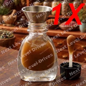 May include: A clear glass bottle with a brown liquid inside, a stainless steel funnel, and a black cap with a white applicator. The bottle is on a wooden surface. The image has the text "Next Level Drives".