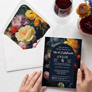 May include: A bridal shower invitation card and matching envelope featuring a dark floral print with yellow, pink, and red flowers. The card displays text including "Sip & Celebrate ANGIE", "SAT 4 Apr", and "RSVP" against a dark blue arched background.