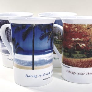 以下が含まれることがあります： さまざまな風景デザインが施された、白いセラミックマグカップ4個セット。ヤシの木のあるビーチの風景、紅葉の風景、街の風景が描かれています。各マグカップの底には引用句が書かれています。