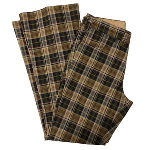 May include: A pair of plaid pants in a classic pattern. The pants feature a green, tan, and black plaid design. The pants are folded and appear to be made of a woven fabric. The pants have a wide leg design.