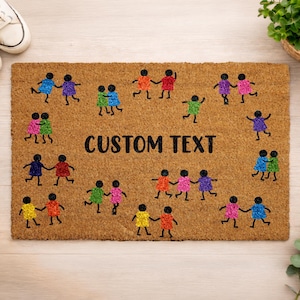May include: A rectangular doormat with a brown background features colorful stick figures holding hands. The words "CUSTOM TEXT" are in black block letters. White sneakers and a potted plant are in the background.