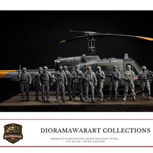 May include: A detailed resin military model diorama featuring a helicopter and a group of soldiers. The figures are hand-painted and stand on a wooden base. The helicopter has yellow and black accents. The diorama is set against a dark background.