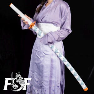 May include: A white and blue katana with orange accents is held by a person wearing a lavender kimono and white obi. The katana has a geometric pattern and is set against a black background. The logo "FSF" is visible in the lower left corner.
