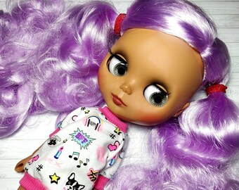 May include: A custom Blythe doll with long, wavy, lavender hair styled in pigtails with red hair ties. The doll has large eyes and is wearing a white and pink patterned dress with the word "BFF" in a speech bubble.
