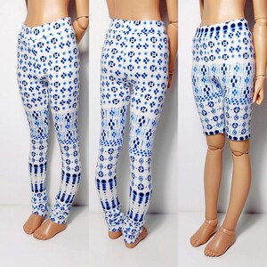 May include: White leggings with a blue and white geometric pattern. The leggings are fitted and have a high waist.