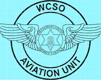 May include: Black and white Aviation Unit logo for Williamson County Sheriff's Office. The design features a circular emblem with text, wings, and a star-shaped badge. The text includes "WCSO", "Williamson County", "Sheriff's Office", and "Aviation Unit".