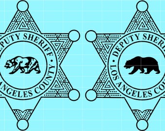 May include: Two black and white Deputy Sheriff badges from Los Angeles County. Each badge is a six-pointed star with the words "Deputy Sheriff" and "Los Angeles County" encircling a bear silhouette.