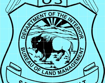 May include: A black and white graphic of a badge with the text "US" at the top, and an eagle above it. The badge reads "DEPARTMENT OF THE INTERIOR" and "BUREAU OF LAND MANAGEMENT". The words "SPECIAL AGENT" are also visible.