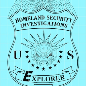 May include: Black and white badge design with the text "HOMELAND SECURITY INVESTIGATIONS" and "EXPLORER". The badge features an eagle at the top and the words "U.S. DEPARTMENT OF HOMELAND SECURITY".