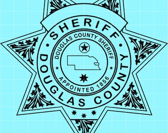 May include: Black and white Douglas County Sheriff badge design. The badge is a seven-pointed star shape with the words "SHERIFF" and "DOUGLAS COUNTY SHERIFF" in a circular pattern. The badge also includes the text "APPOINTED 1856".
