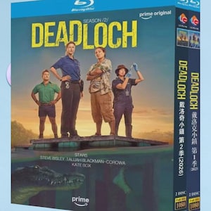 May include: Blu-ray disc for the TV series "Deadloch" Season 2. The cover features a group of four people standing on a wooden platform with a crocodile in the water below. The title is in large yellow letters.
