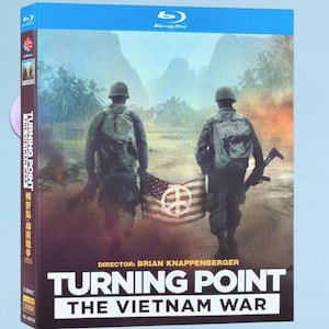 Könnte beinhalten: Blu-ray-Disc-Hülle für "Turning Point: The Vietnam War". Das Cover zeigt zwei Soldaten mit einer Flagge mit einem Friedenssymbol. Der Titel steht in großen weißen Buchstaben, darunter der Name des Regisseurs.