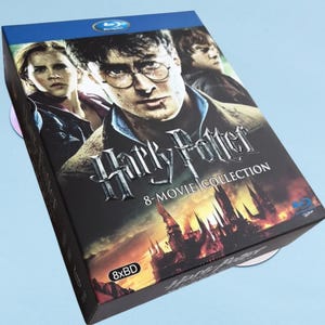 May include: A Harry Potter 8-Movie Collection Blu-ray box set. The box features the film's title and images of the main characters. The box is black with a blue top and includes the 8xBD logo.