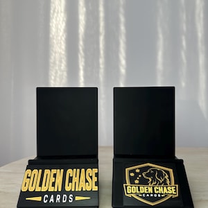 May include: Two black card display stands with gold lettering that reads "GOLDEN CHASE CARDS". One stand has the text, the other has a logo of a golden retriever dog.