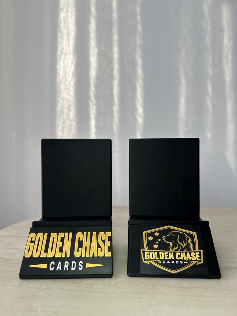 May include: Two black card display stands with gold lettering that reads "GOLDEN CHASE CARDS". One stand has the text, the other has a logo of a golden retriever dog.