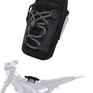 May include: Black motorcycle phone bag with a lace-up design. The bag has a zipper closure and a small logo on the top. The bag is designed to attach to a motorcycle.