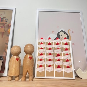 Puede incluir: Figuras de madera con detalles de corazón rojo junto a una exhibición de pequeños sobres. Cada sobre está sellado con un corazón rojo y contiene un mensaje. Una ilustración enmarcada de un ángel con corazones está en el fondo.