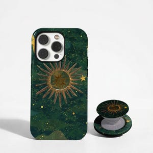 Op de afbeelding: Een donkergroen smartphonehoesje en een bijpassende ronde, inklapbare telefoonhouder. Beide items hebben een hemels ontwerp met een centrale gouden zonnestraal, verspreide gele sterren en kleine gouden stippen op een diepgroene achtergrond.