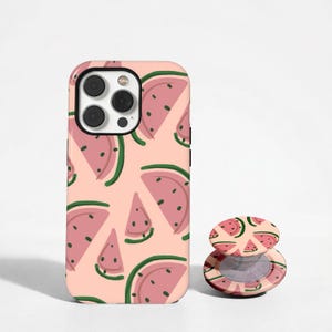May include: A pink phone case and matching phone grip with a repeating pattern of watermelon slices. The watermelon slices are pink with green rind and black seeds, set against a light pink background.