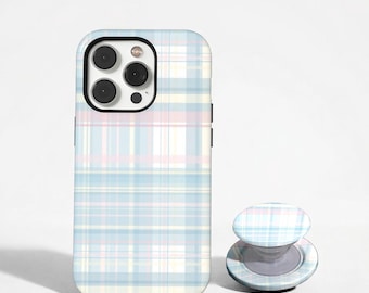 May include: A pastel plaid phone case and matching phone grip. The case is light blue, pink, and yellow with a grid pattern. The phone grip is round and has a similar plaid design. The phone case is designed to fit a smartphone.