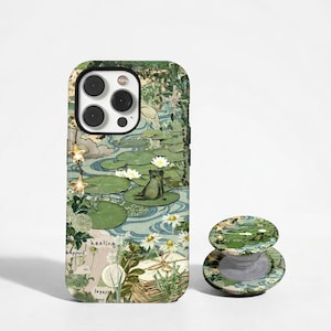 Puede incluir: Funda de teléfono y agarre a juego con un diseño de naturaleza. La funda y el agarre presentan una rana en un nenúfar, con una combinación de colores verde, azul y blanco y elementos florales.