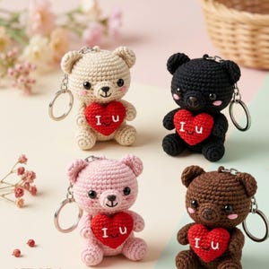 Puede incluir: Cuatro llaveros de oso de ganchillo en crema, negro, rosa y marrón. Cada oso tiene un corazón rojo con "I u" bordado. Los llaveros tienen anillos plateados.