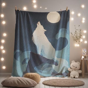 Op de afbeelding: Een rechthoekig wandkleed met een witte wolf die naar een grote, lichtgele maan huilt tegen een donkerblauwe nachtelijke hemel. Het ontwerp bevat gestileerde lichtblauwe wervelende wolken of golven aan de basis, met de wolf zittend op een donkere rots.