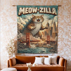May include: A wall tapestry featuring a cartoon cat as a giant monster, titled "MEOW-ZILLA." The artwork depicts the cat destroying a city, with the Golden Gate Bridge in the foreground. The color palette includes shades of brown, blue, and orange.