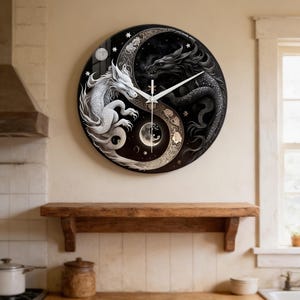 Puede incluir: Reloj de pared redondo con un diseño de yin-yang con dos dragones. Un dragón es blanco, el otro negro. La esfera del reloj tiene un fondo estrellado y detalles de luna. Las manecillas son blancas.