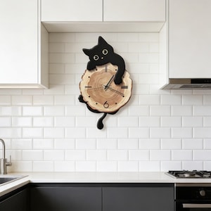 May include: A whimsical wall clock featuring a black cat perched atop a wooden clock face. The clock face is a natural wood slice with visible grain and black clock hands. The cat's tail dangles below, adding a playful touch to this unique home decor item.