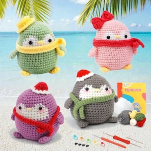 May include: Four handmade crochet penguin figures in various colors: green, pink, purple, and gray. Each penguin has a scarf and hat. The background shows a beach scene with palm leaves and the ocean. A DIY penguin kit is also included.