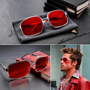 May include: Sunglasses featuring rectangular frames with a metallic silver finish and vibrant red lenses. The design includes thin temples and a bridge, providing a clear view of the bold red tint through the lenses in this eyewear accessory.