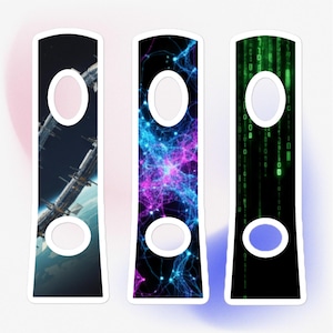 May include: Three rectangular stickers with white borders and oval cutouts. The designs include a space station, a nebula in blue and purple, and a green matrix-style pattern. The stickers are on a white background with a pink gradient.