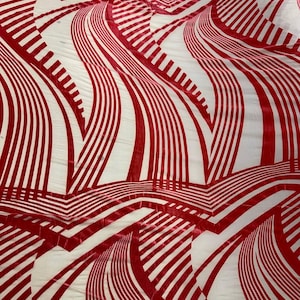 May include: A fabric with a repeating pattern of red, curved, vertical stripes against a white background. The stripes vary in width and create a flowing, wave-like design. The fabric appears to be soft and possibly velvet.