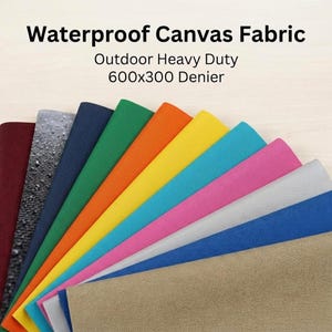 May include: A fan-shaped display of waterproof canvas fabric swatches in various colours including maroon, black, navy, green, orange, yellow, teal, pink, grey, blue, and tan. Text reads: Waterproof Canvas Fabric Outdoor Heavy Duty 600x300 Denier.