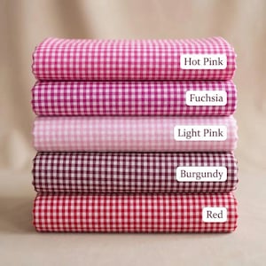 May include: Five folded fabrics in a gingham pattern, in shades of pink, red, and burgundy. The colours are labelled: Hot Pink, Fuchsia, Light Pink, Burgundy, and Red.