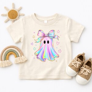 Cute holographic pastel ghost with a bow surrounded by stars and hearts, trendy toddler girls halloween shirt design.