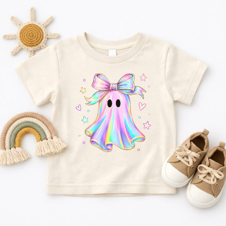 Cute holographic pastel ghost with a bow surrounded by stars and hearts, trendy toddler girls halloween shirt design.