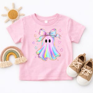 Cute holographic pastel ghost with a bow surrounded by stars and hearts, trendy toddler girls halloween shirt design.