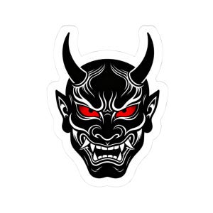 May include: A black and white sticker featuring a Japanese Oni mask design. The mask has red eyes, sharp teeth, and two curved horns. The design is detailed with white lines and a white border.