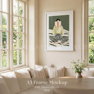 Könnte beinhalten: Ein weiß gerahmter Kunstdruck mit einer Person, die ein Buch liest. Die Person trägt ein gelbes Oberteil und eine Hose mit schwarz-weißen Streifen. Der Text "A3 Frame Mockup" befindet sich unten.