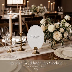 May include: An oval wedding sign mockup featuring a white surface with a subtle gray diamond pattern, held by a brass stand. The sign displays the text 'YOUR IMAGE HERE' in the center, positioned on a table with candles and white flowers.