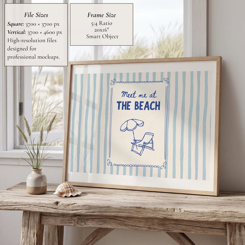 May include: A framed print with a beach theme. The artwork features blue and white vertical stripes, with a central design that reads "Meet me at THE BEACH" and includes a beach umbrella and chair. The frame is a light wood colour.