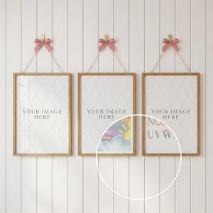 May include: Three framed prints with wooden frames suspended by string and red and white gingham bows. Each print has a white diamond patterned background and the text "YOUR IMAGE HERE". The prints are hanging on a white wall.