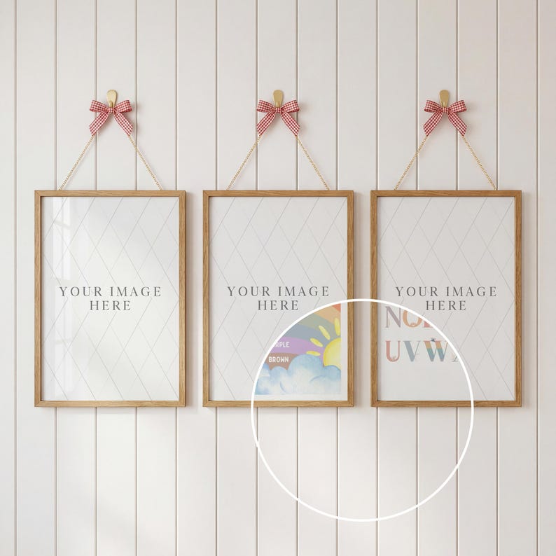 May include: Three framed prints with wooden frames suspended by string and red and white gingham bows. Each print has a white diamond patterned background and the text "YOUR IMAGE HERE". The prints are hanging on a white wall.